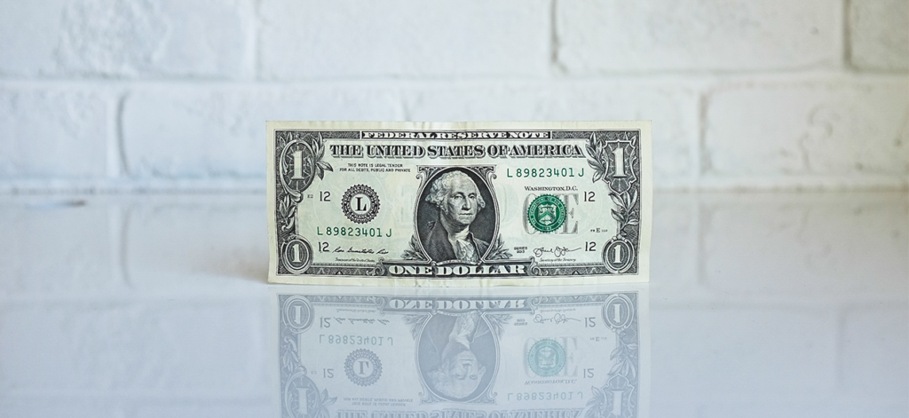 Dollar Bill on White Counter with Reflection