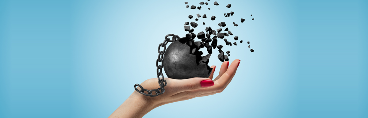 Female hand holding a ball and chain that is breaking apart