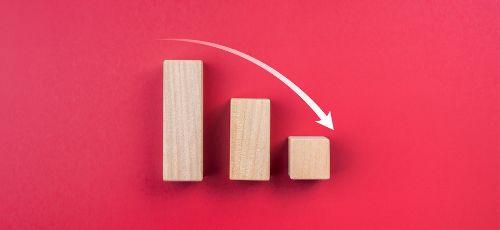 Wood blocks showing a declining bar chart on a red background