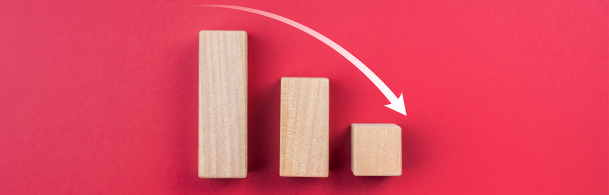 Wood blocks showing a declining bar chart on a red background