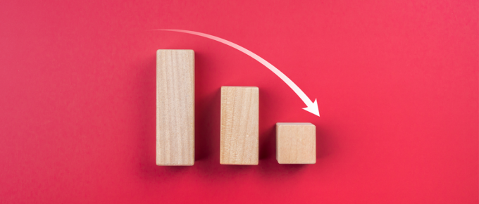 Wood blocks showing a declining bar chart on a red background
