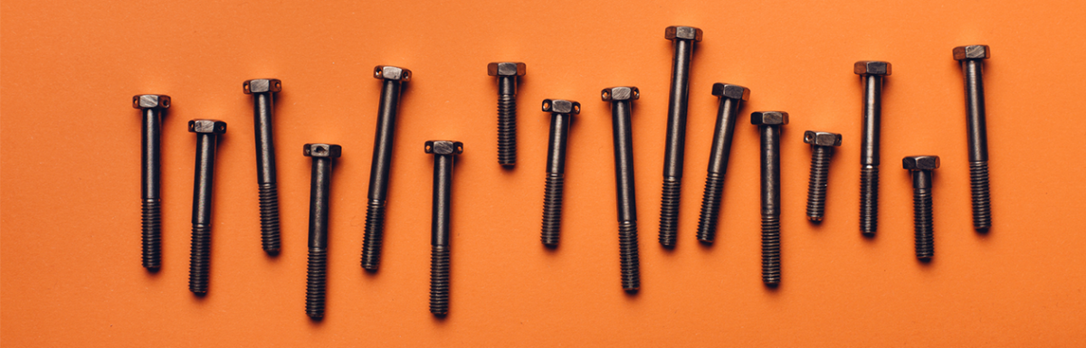A row of black screws on an orange background